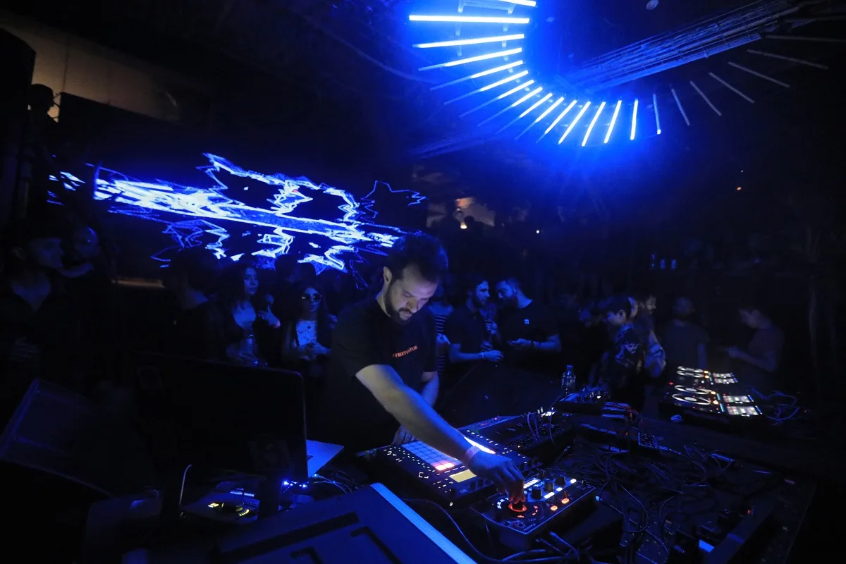 Nowhere Traveler en vivo frente al público, con luces azules y visuales proyectados